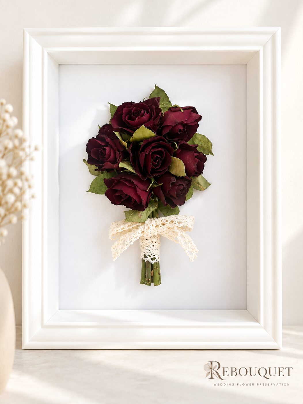 Preserved burgundy rose bouquet in a white shadow box frame with lace ribbon